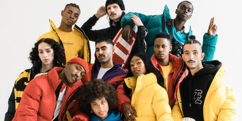 un gruppo di modelli di diverse etnicità posano per una foto di moda
