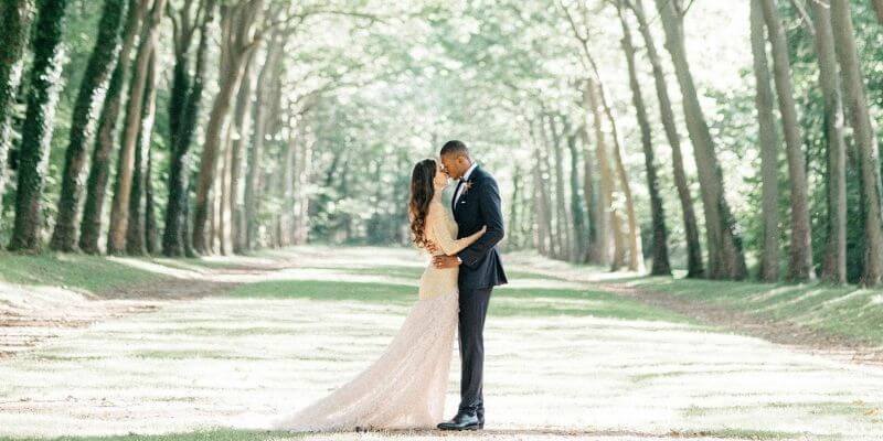 una coppia si bacia sotto gli alberi nelle foto di nozze