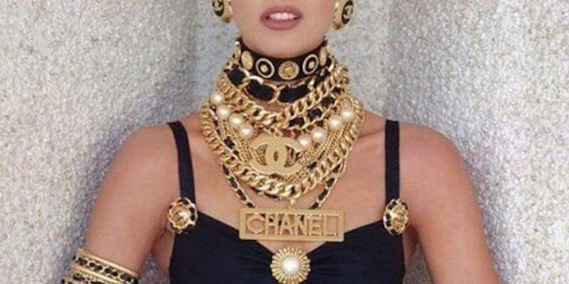 un dettaglio di linda evangelista che indossa vistosa bigiotteria con logo Chanel