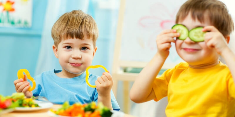 due bambini giocano con delle verdure