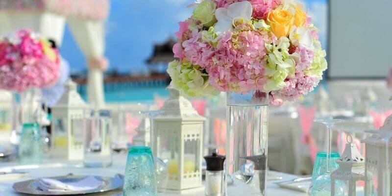 una tavola imbandita con dei fiori color pastello alle maldive