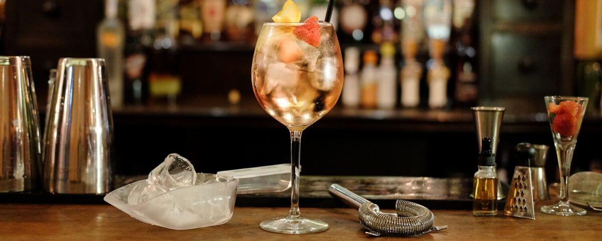 un bicchiere con un cocktail appoggiatosul bancone del bar