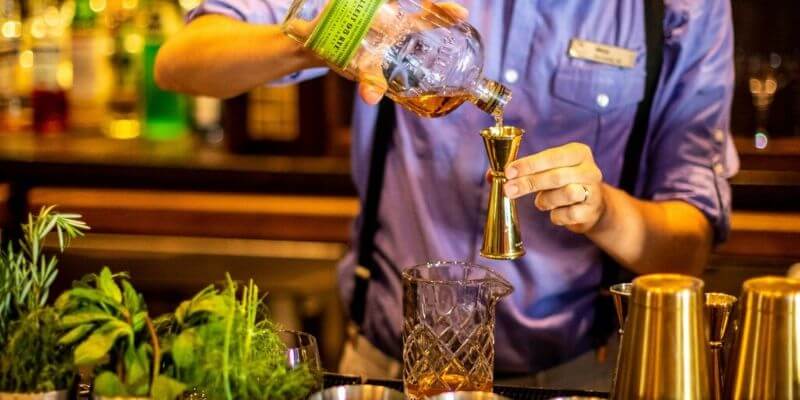 un barman misura gli ingredienti per un cocktail