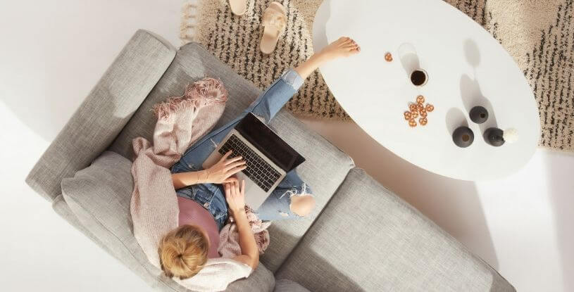 una ragazza che lavora al pc su un divano vista dall'alto