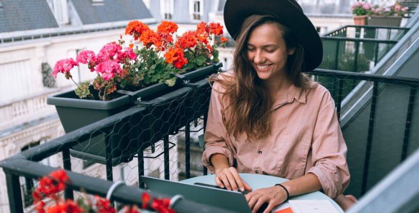 una ragazza al computer sul balcone di casa