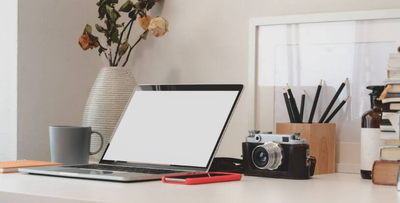 una scrivania con un computer e una macchina fotografica