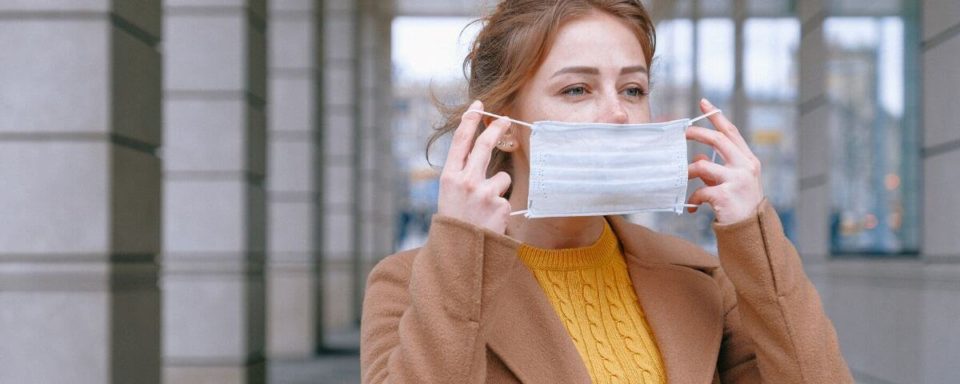 una ragazza indossa una mascherina all'esterno
