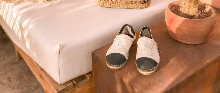 un paio di espadrillas chanel vicino a un divano